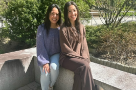 Leni and Michelle Lemos sit outside of the 彼得T. Paul College of Business and 经济学.